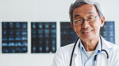 Smiling doctor in front of x-rays