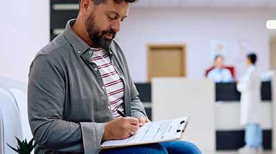 Patient filling out medical plan form.