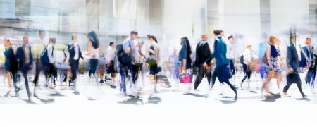 A busy crowd walking by buildings.